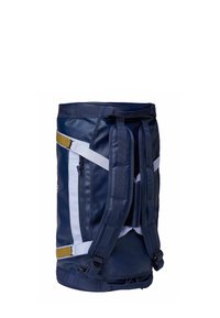 Sac de sport bleu marine avec des accents blancs et dorés, doté de sangles rembourrées, d'une poignée supérieure et d'une poche latérale zippée. Matériau imperméable.