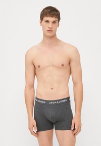 Dunkelgraue Boxershorts aus einem weichen, dehnbaren Stoff mit einem elastischen Bund, auf dem der Markenname "JACK & JONES" in Weiß abgedruckt ist.