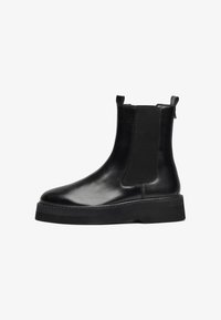 Bottes chevilles en cuir noir avec panneaux latéraux �élastiques, bout rond et semelle en caoutchouc épaisse. Design épuré avec des accents minimaux.