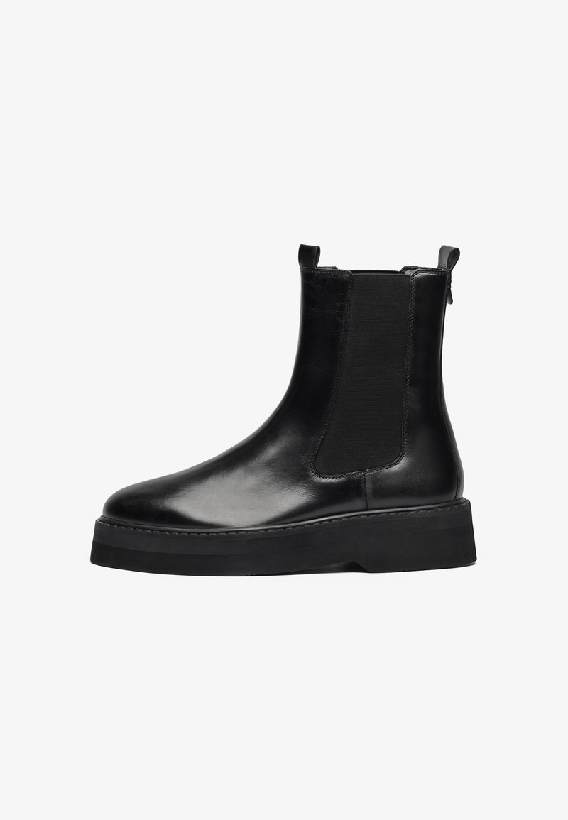 Bottes chevilles en cuir noir avec panneaux latéraux élastiques, bout rond et semelle en caoutchouc épaisse. Design épuré avec des accents minimaux.