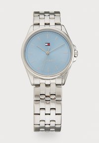 Silver metal watch with a round face, light blue dial, thin markers, and a logo. Features a linked bracelet style strap.