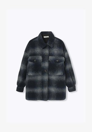 Chemise veste en mélange de laine à carreaux bleu foncé et gris, dotée de deux poches poitrine et de boutons noirs. Coupe décontractée et manches longues.