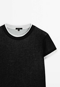 Black short-sleeve t-shirt with a textured fabric. Features a white and black ribbed crew neckline and contrasting cuff accents.