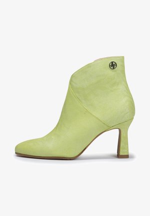 Bottine vert citron avec un tissu texturé, bout pointu et un talon de hauteur intermédiaire. Présente un petit logo près du haut.