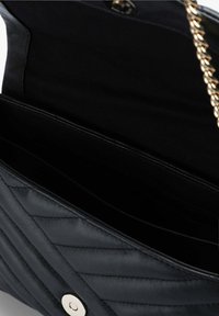 Borsa a tracolla in pelle nera con design trapuntato, accessori in oro e una tracolla a catena. L'interno presenta due scomparti e una fodera in tessuto liscio.