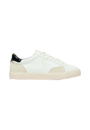 Zapatilla blanca de caña baja con detalles en ante beige, lengüeta negra en el talón, cierre de cordones y suela de goma.