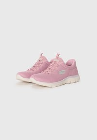 Light pink athletic shoes made of mesh material, featuring a rounded toe, textured surface, white rubber sole, and laces.