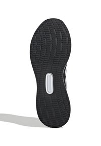 Black rubber shoe sole with a textured tread pattern, featuring white accents and a distinct cutout in the midsole for flexibility.