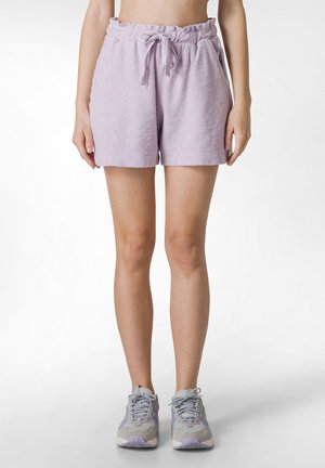 Lavender frotté shorts med elastisk talje og snøre. De har en afslappet pasform og blød tekstur. Båret med grå sneakers.