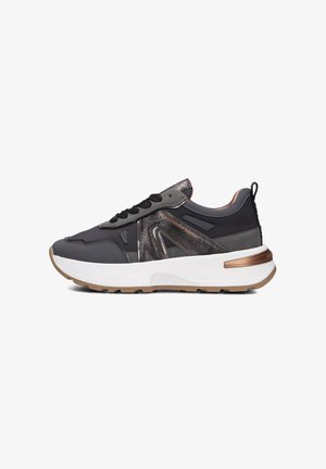 Scarpe sportive realizzate in materiale sintetico nero con accenti metallici, dotate di una robusta intersuola bianca, dettagli testurizzati e suola in gomma.