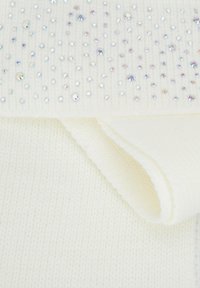 Tissu tricoté blanc à texture lisse, parsemé de strass irisés dispersés sur le dessus. Un bord plié révèle une douceur.