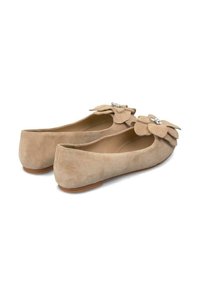 Beige suède balletschoenen met grote stoffen bloemaccenten en decoratieve hardware op de neus. Rondneus ontwerp met een lage hak.