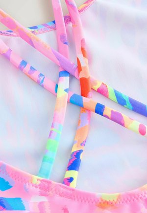 Růžový plavkový top se barevnými křížovými popruhy s abstraktními vzory. Materiál se zdá být hladký a elastický, vhodný pro vodní aktivity.