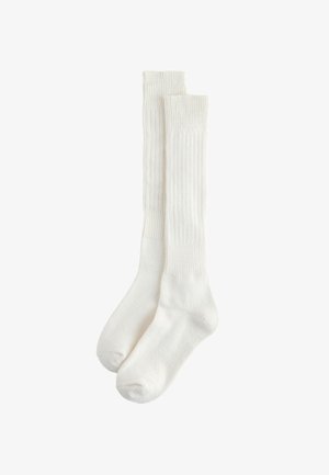 Paar schlichte weiße gerippte Knöchelsocken, flach und überlappend, isoliert auf weißem Hintergrund.