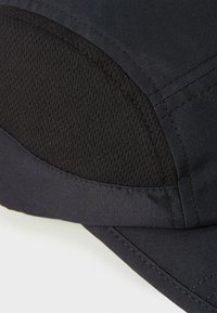 Svart caps med glatt stoff og teksturert mesh-panel, med presis søm og buet brem. Minimalistisk design.