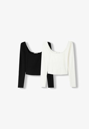 Twee langwerpige crop tops met lange mouwen in zwart en wit. De tops hebben een ronde halslijn en een getailleerd ontwerp met een soepele, rekbare stof.