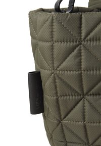 Quilted olivengrønn veske med en teksturert overflate, utstyrt med et svart plastikkgrep og et sidemerke med preget skrift.