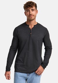 Schwarzes Langarm-Henley-Shirt aus weichem Stoff, mit einer Knopfleiste und drei braunen Knöpfen sowie einem abgerundeten Saum. Lässige Passform.