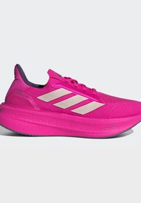 Lyserød løbesko med hvide Adidas-striber, tyk polstret sål, lav ankellukning og snørelukning på ensfarvet baggrund.