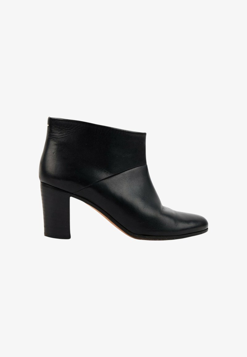 Bottine en cuir noir avec talon bloc, bout arrondi et dessus lisse, vue de côté extérieur sur fond blanc.