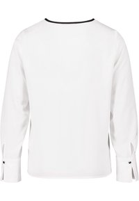 Blouse blanche à manches longues avec un col noir. Les manches sont dotées d'un poignet boutonné et d'un détail fente, avec une texture lisse et douce.