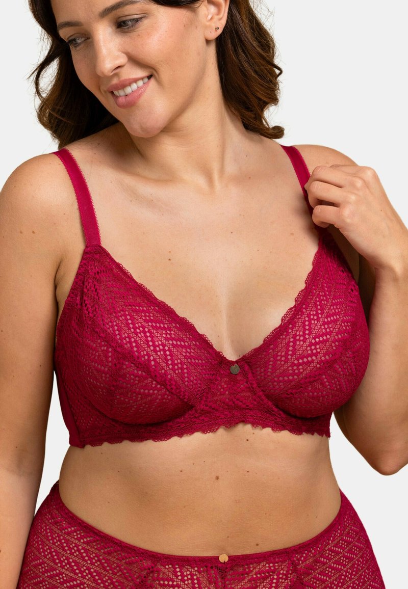 Bralette en dentelle de couleur bourgogne profond avec un motif géométrique, des bretelles réglables et un détail central de bouton décoratif. Fini doux et texturé.