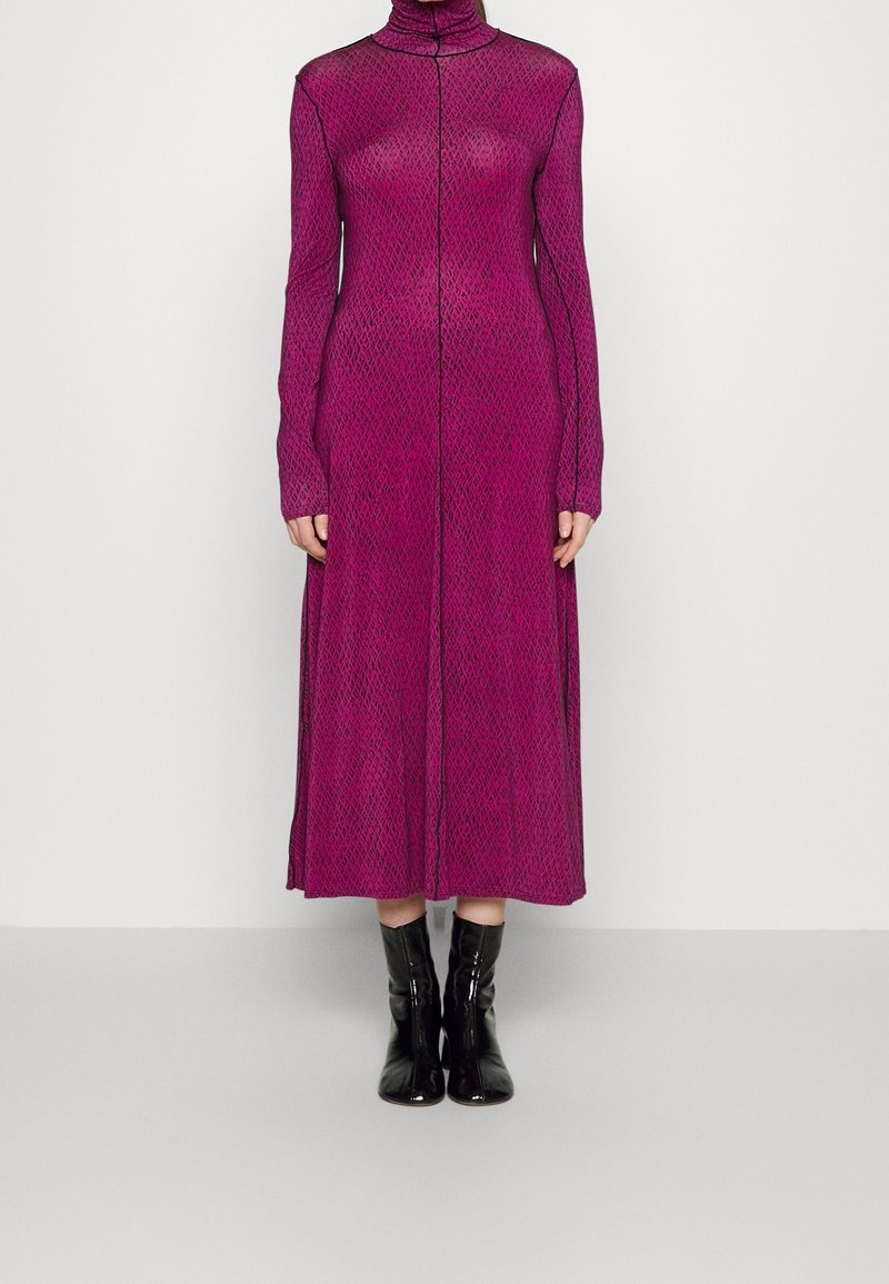 Long, fitted dress in bright fuchsia mesh with a turtleneck and long sleeves, featuring a geometric pattern and a front seam detail.