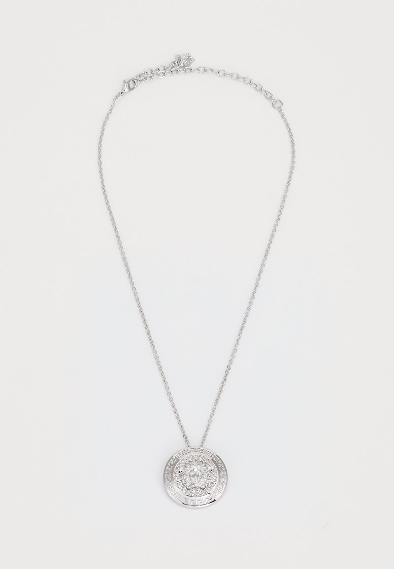 Ασημένιο κολιέ με κυκλικό μενταγιόν που διαθέτει περίπλοκες λεπτομέρειες και έναν κεντρικό λίθο. Η αλυσίδα είναι λεπτή με κούμπωμα αστακού.