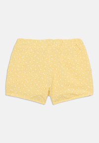 Gule shorts laget av myk stoff, med et spredt hvitt mønster. Elastisk midjebånd og glatte kanter for komfort.