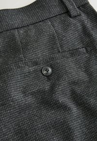 Gray patterned trousers featuring a smooth texture, single back pocket, and a black button closure.