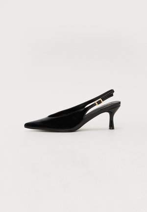 Pompe slingback en cuir verni noir avec un bout pointu, un petit talon et une attache en or sur la bride. Texture lisse et design élégant.