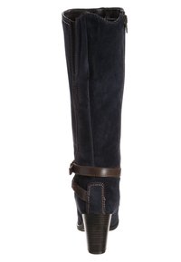 Bota de ante azul marino hasta la rodilla con cremallera lateral, detalle de correa marrón, costuras en contraste y tacón apilado. Textura suave y diseño ajustado.