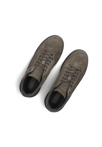 Braune Wildleder-Sneaker mit niedrigem Profil, abgerundeter Zehenpartie, flachen Schnürsenkeln und einer schwarzen Gummisohle. Verfügt über durchbrochene Details an den Seiten.