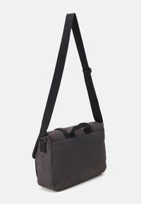 Borsa a tracolla nera realizzata in tessuto resistente, con forma rettangolare, manici superiori e una tracolla regolabile per indossarla sulla spalla.