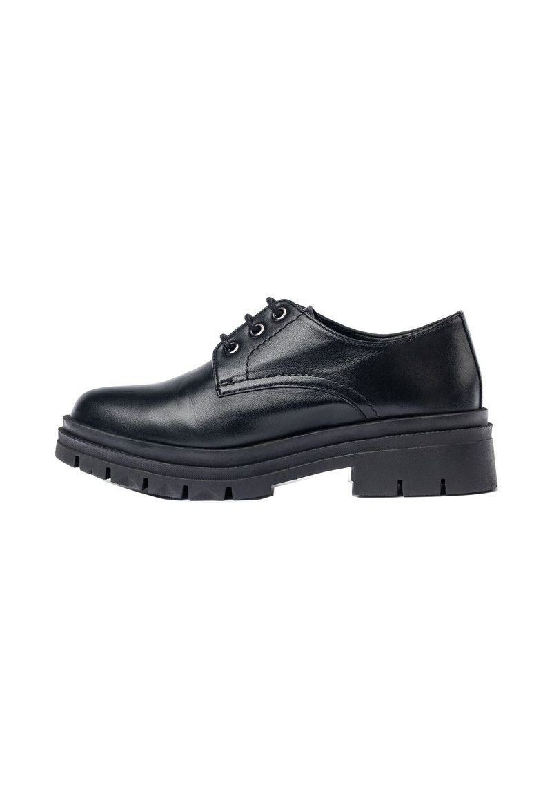 Zapato oxford de cuero negro con punta redondeada, acentos cosidos y una suela de goma negra gruesa y resistente con un patrón de profundidad.