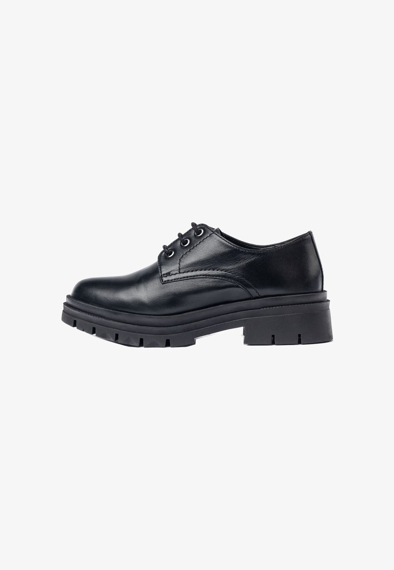Zapato oxford de cuero negro con punta redondeada, acentos cosidos y una suela de goma negra gruesa y resistente con un patrón de profundidad.