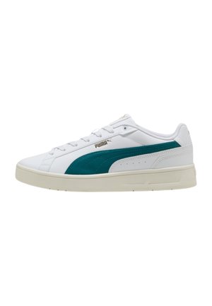 Scarpa da ginnastica Puma bassa bianca con striscia laterale turchese, suola crema, lacci e logo Puma dorato sul lato e sulla linguetta.