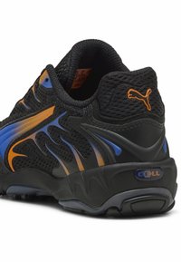 Zapatilla deportiva negra con parte superior de malla, acentos en azul y naranja, detalles texturizados y suela acolchada. Presenta un prominente logo de "CELL".