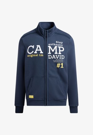 Navy blue zip-up sweatshirt made of soft fabric with stand-up collar. Features printed text in white, yellow, and black. Two front pockets.