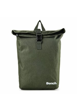 Sac à dos à rabat roulé vert foncé avec fermeture à boucle noire et logo "Bench." en bas à droite à l'avant.