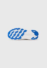 Semelle de chaussure de sport, avec une base blanche et des motifs de grip en caoutchouc bleu. Rides texturées notables pour la traction et le soutien.