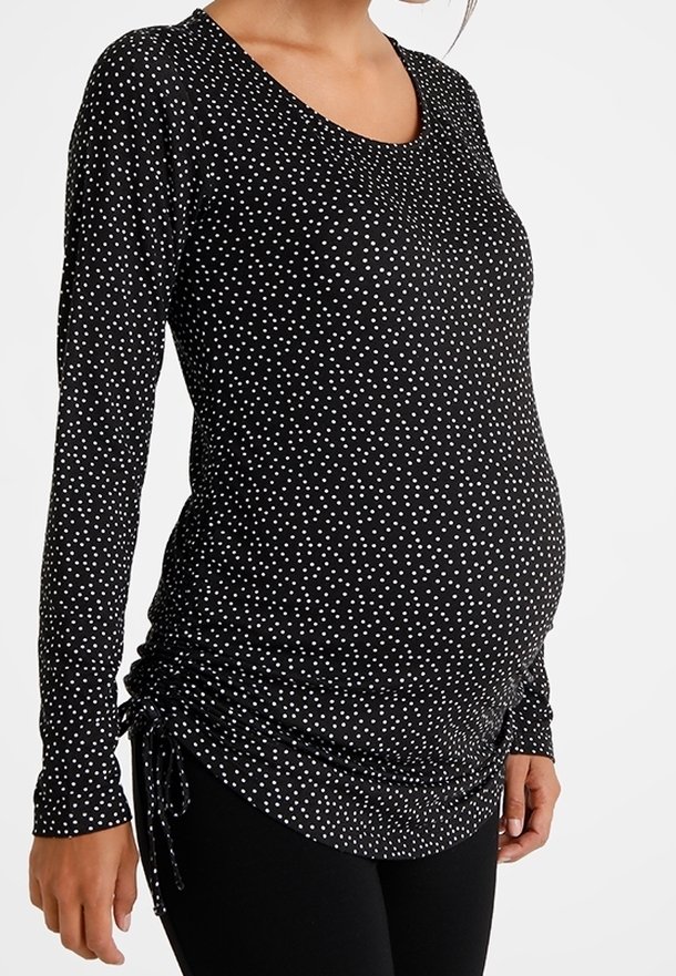 Schwarzes, langärmliges Umstandsshirt mit weißen Punkten, featuring geraffte Seiten für Stretch und Komfort sowie einem tiefen V-Ausschnitt.