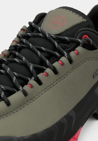Turistická obuv s čiernym a olivovo zeleným syntetickým vrchom, červenými akcentmi, textúrovaným systémom šnurovania a robustnou čiernou podrážkou so vzorovanou gripou.
