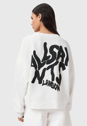 Hvid oversized sweatshirt med en iøjnefaldende sort, abstrakt tekst på ryggen. Blødt materiale med en afslappet pasform og sænkede skuldre.