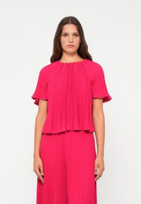 Rosa plissiertes Oberteil mit kurzen Ärmeln, runder Ausschnitt und flared Saum, aus einem leichten, strukturierten Stoff gefertigt.