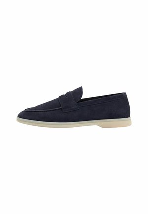 Mocassins en daim bleu marine avec une semelle en caoutchouc crème plate, présentant un bout arrondi et un simple accent de sangle à l'avant.