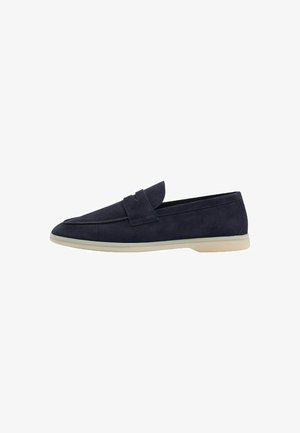 Mocassini in suede blu navy con suola piatta in gomma color crema, caratterizzati da una punta rotonda e un semplice dettaglio a fascetta nella parte anteriore.