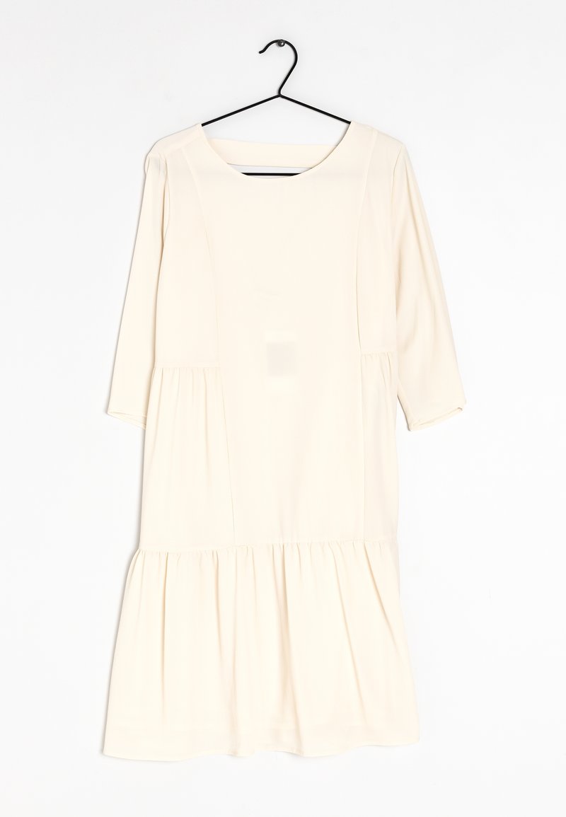 Robe ivoire à manches 3/4, décolleté arrondi et ourlet à volants en couches. Fabriquée en tissu doux avec une texture lisse.