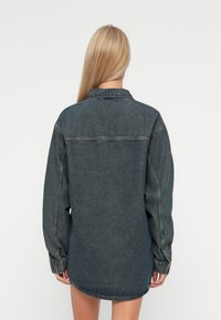 Jeans srajca v temnem pranju, z ovratnikom, dolgimi rokavi in rahlo ukrivljenim robom. Klasično šivanje in detajli gumbov.