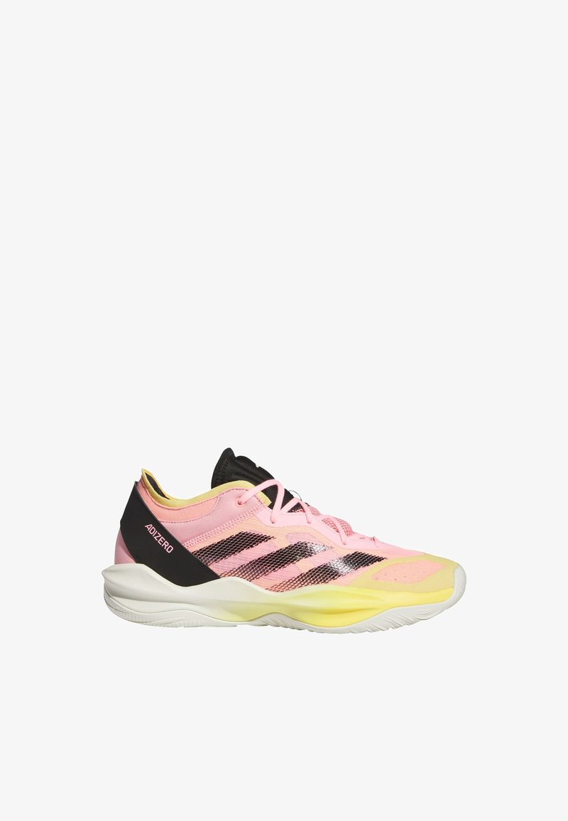 Des chaussures de sport légères en rose et jaune, avec une tige en maille, des accents noirs et trois bandes noires sur le côté. Semelle en caoutchouc.